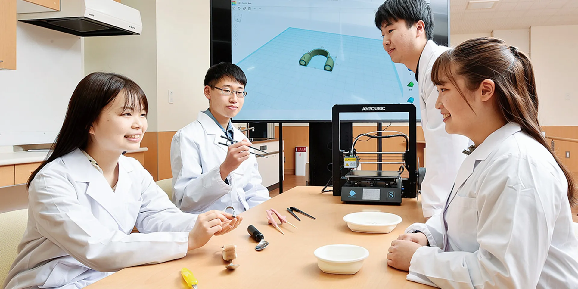 医療実習を行う学生たちが、3Dプリンターや実験器具を使っている様子（画像をクリックすると作業療法学科のページへ移動します）。