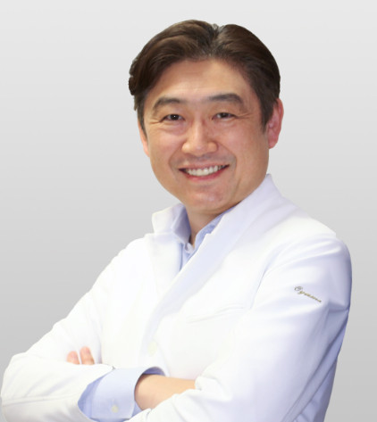 診療科部長の小山明彦教授が白衣を着て微笑んでいるポートレート。