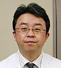 呼吸器外科の主任教授、鈴木弘行氏のポートレート。白衣を着用し、真剣な表情でカメラを見つめている。